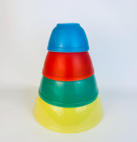 Stack of colorful PYREX mixing bowls on a white background