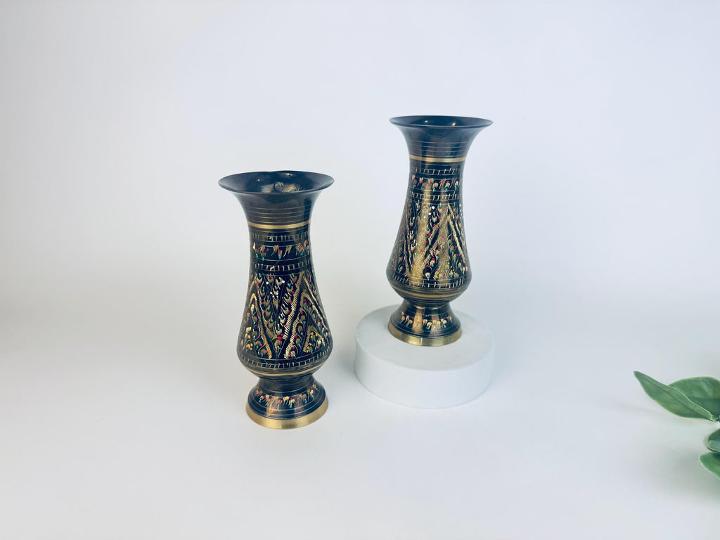 Two decorative vases with black and gold patterns on a white background