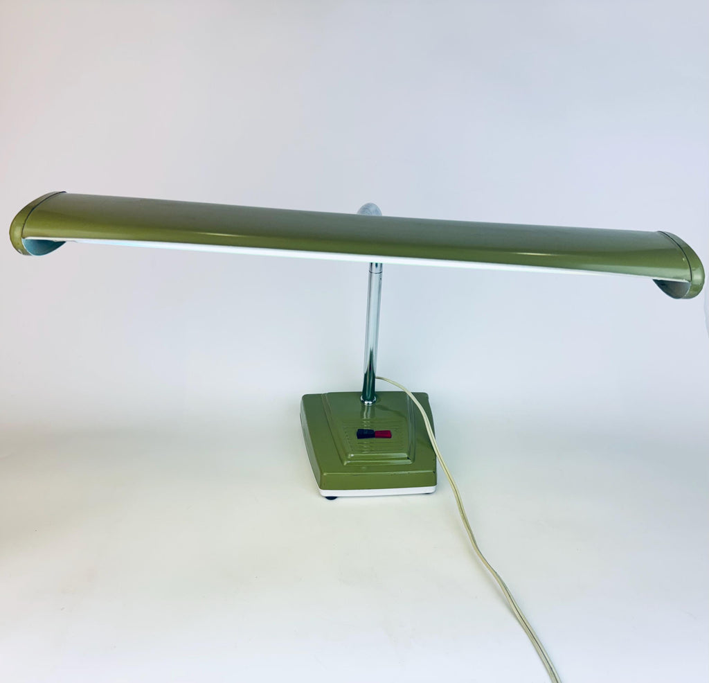 Vintage olive green desk lamp with a long horizontal shade, chrome stem, and rectangular base featuring red and blue toggle switches.