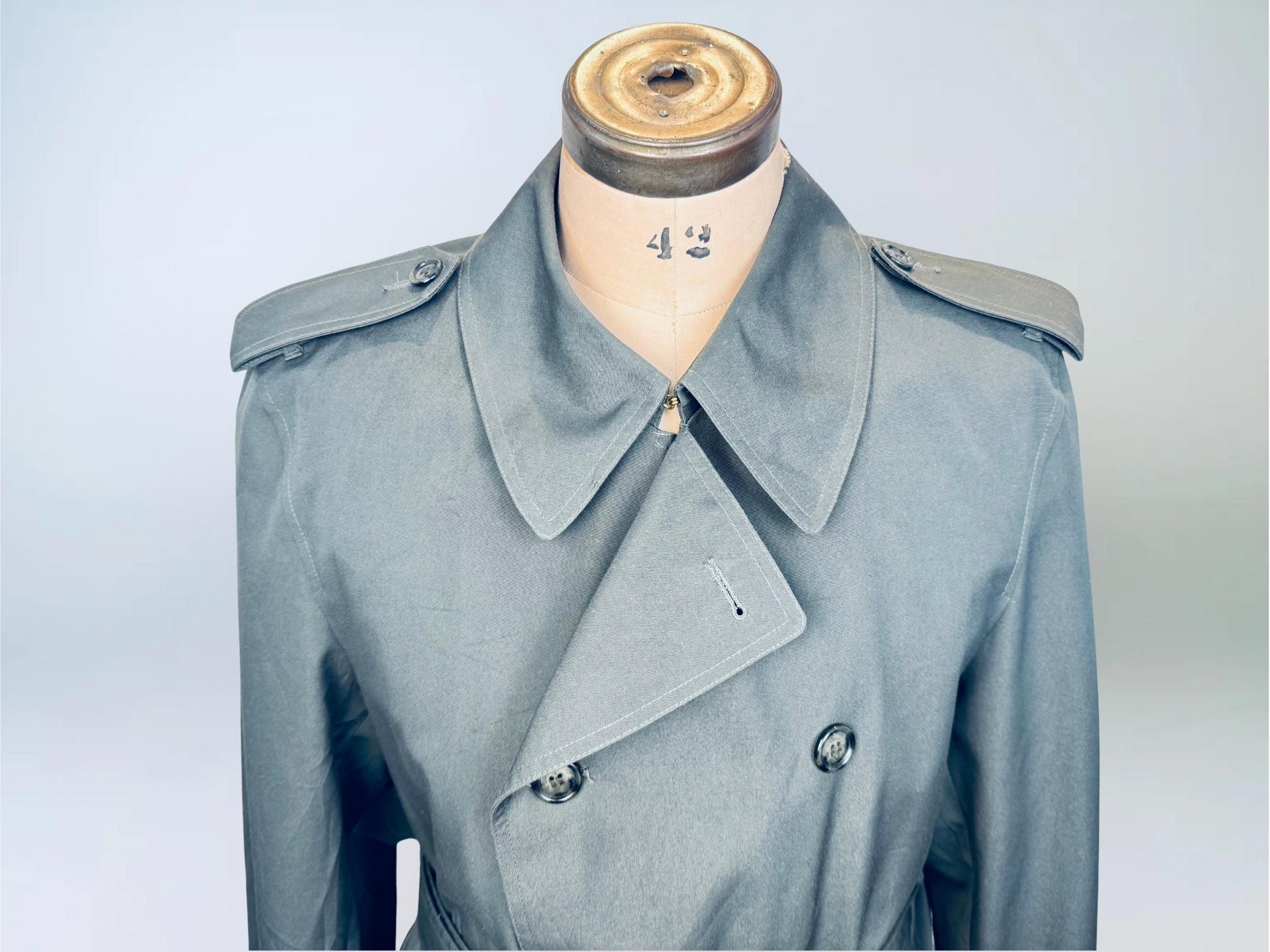 Gray LONDON FOG trench coat on a mannequin against a light gray background