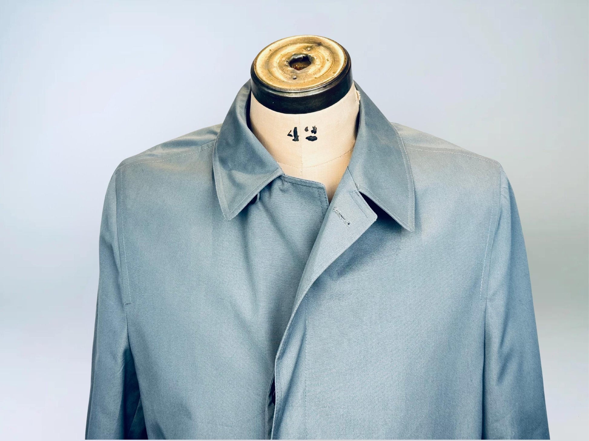 Light grey blue LONDON FOG trench coat on a mannequin with a plain background