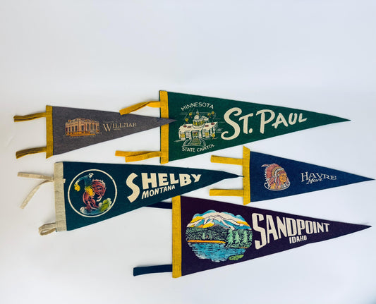 Collection of vintage-style pennants with different locations on a white background