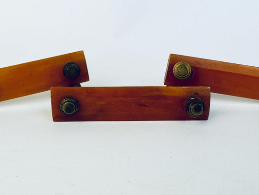 Three butterscotch bakelite handles with brass metal knobs on a white background.