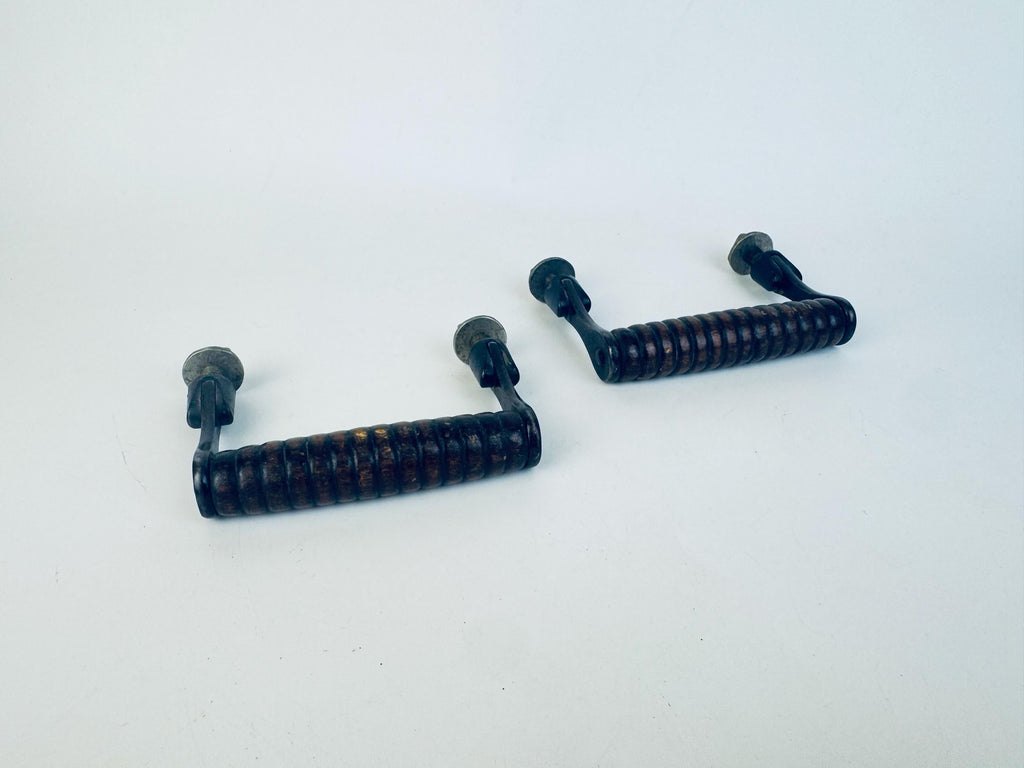 Two ribbed black walnut wood and metal handles on a white background.