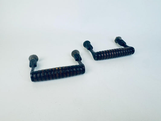 Two ribbed black walnut wood and metal handles on a white background.