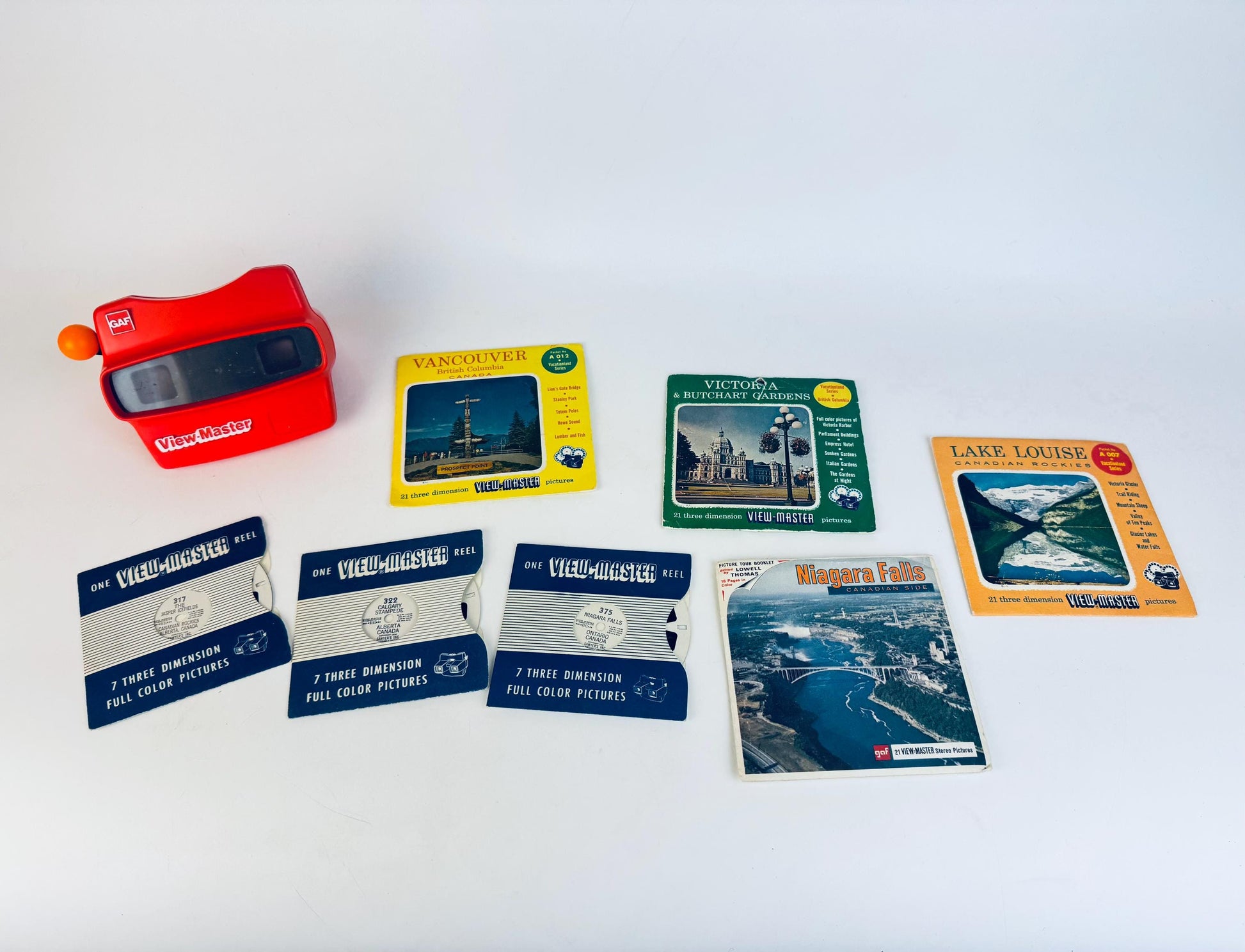 Collection of View-Master reels and a red View-Master device on a white background