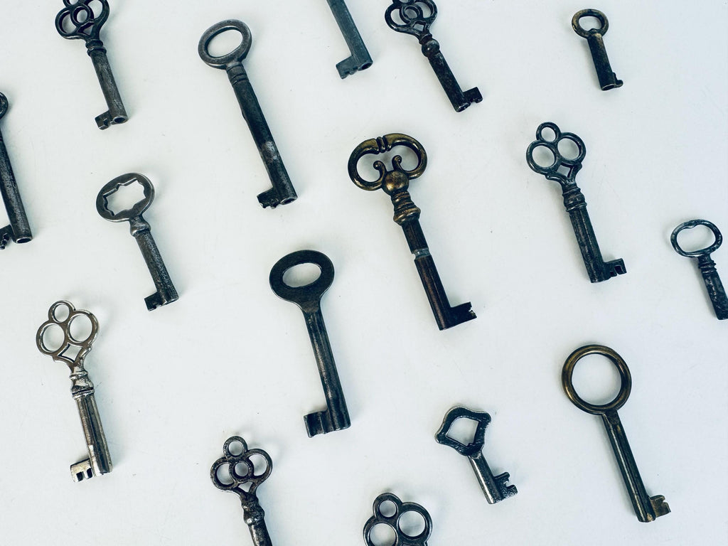 Vintage skeleton keys scattered on a white background.