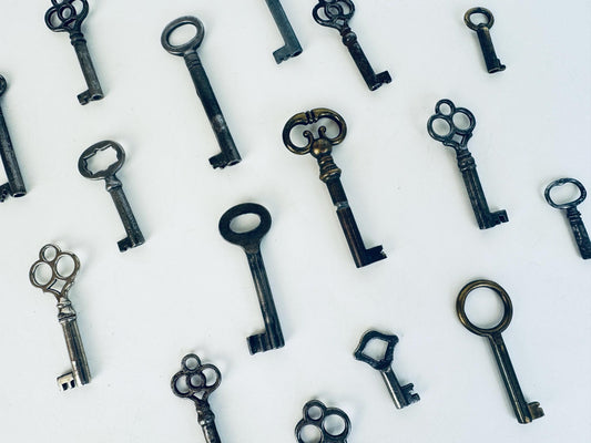 Vintage skeleton keys scattered on a white background.