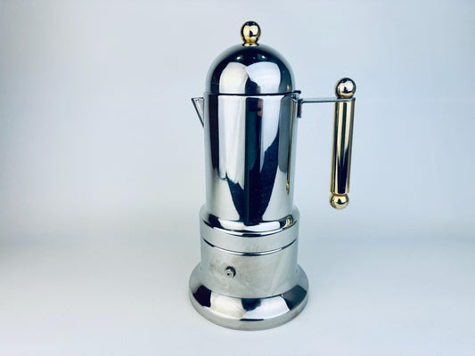 Vintage Italian stainless steel stovetop espresso maker featuring polished silver finish with gold accents on the handle and lid. The piece has a sleek cylindrical design with a domed top and a mid-century modern aesthetic, photographed against a white background.