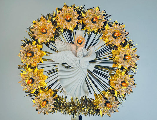 Vintage illuminated Christmas wreath featuring a white angel figurine at the centre, surrounded by gold and black tinsel rays and twelve glowing star-shaped amber lights, arranged in a radiant circular design.