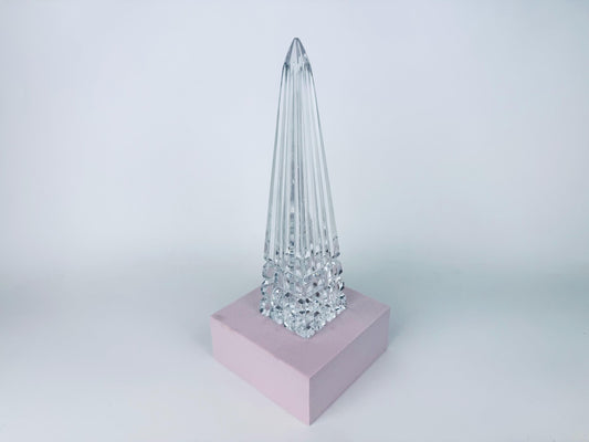 Clear Waterford lead crystal obelisk with tiered block-cut base on white background.