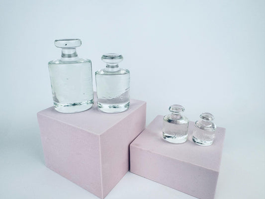 Four-piece vintage solid glass weight set with raised metric markings arranged in a row on a pale background.
