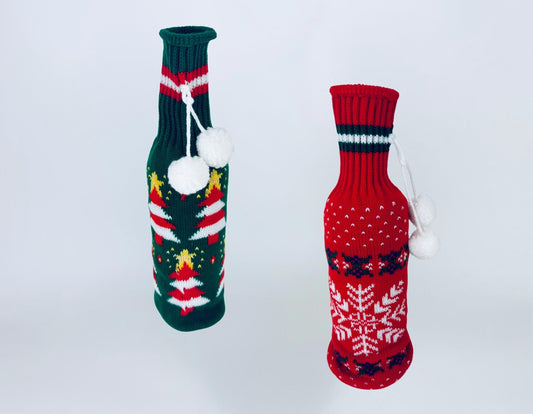 Vintage red and green knit Christmas bottle covers with pom-pom ties displayed against a white background.