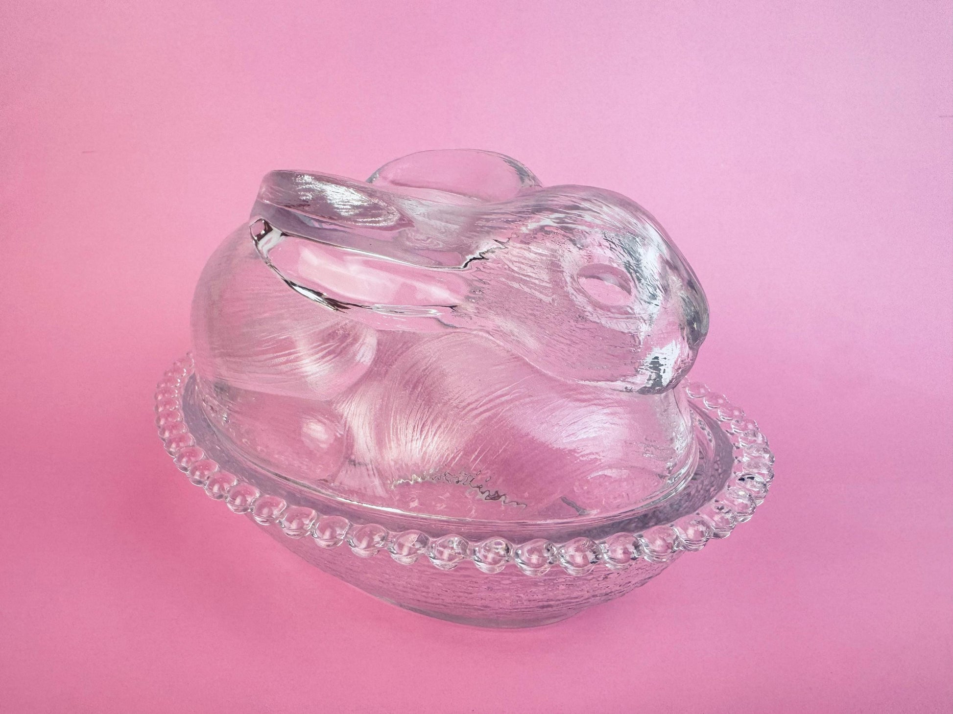Clear pressed-glass bunny-on-nest covered dish with beaded rim, 1970s collectible.