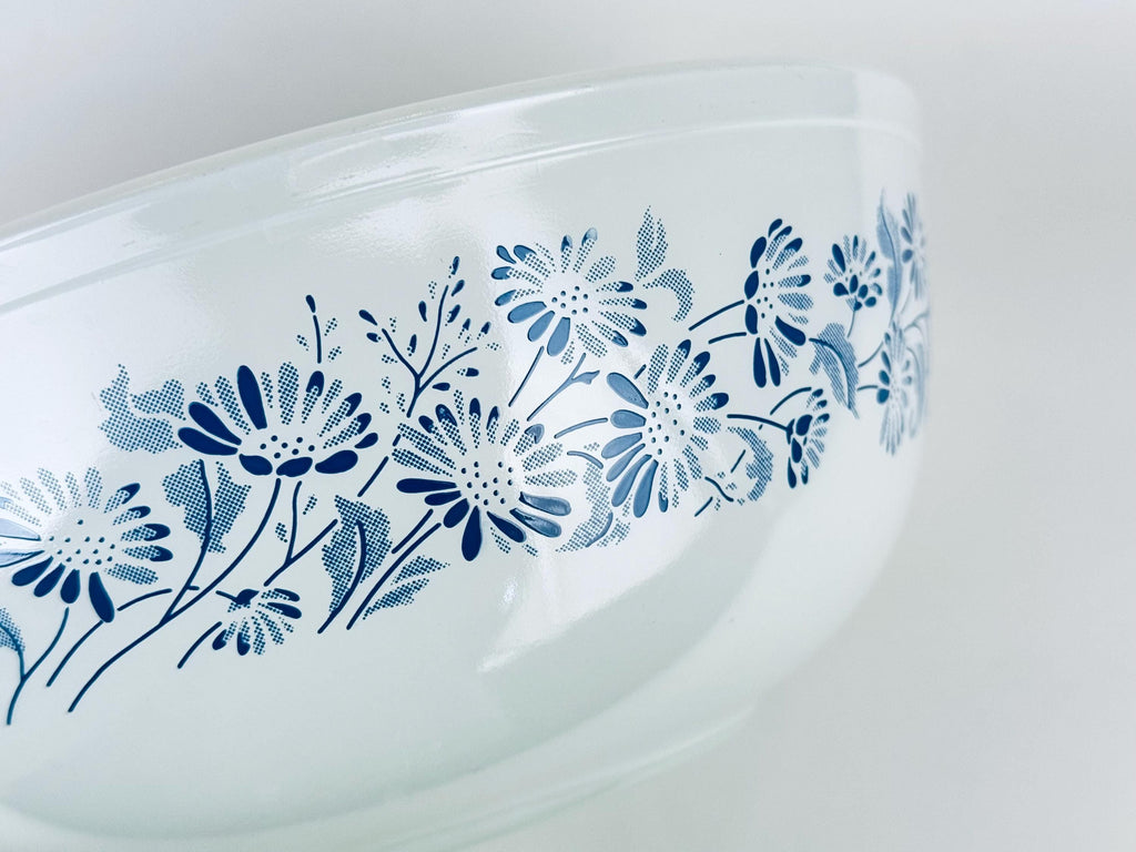 Vintage Pyrex Colonial Mist #404 mixing bowl upside down showing blue floral pattern on white glass.