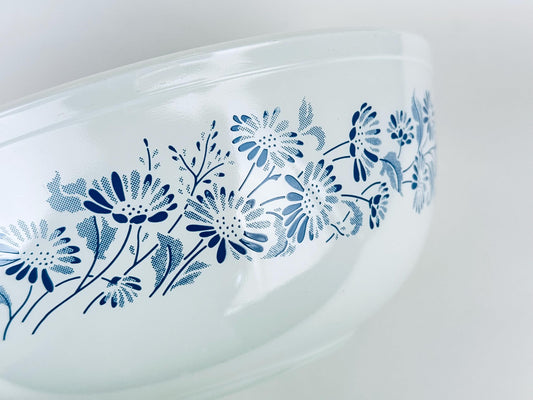 Vintage Pyrex Colonial Mist #404 mixing bowl upside down showing blue floral pattern on white glass.
