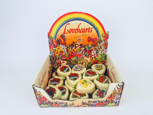 Vintage 1970s cream heart-shaped floral tin candles styled as Valentine’s Day gifts.