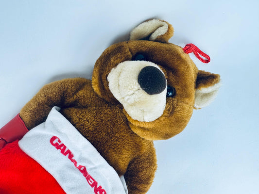 Vintage red plush Montreal Canadiens NHL Christmas stocking with attached brown teddy bear wearing mini red mittens, laid flat on white background.