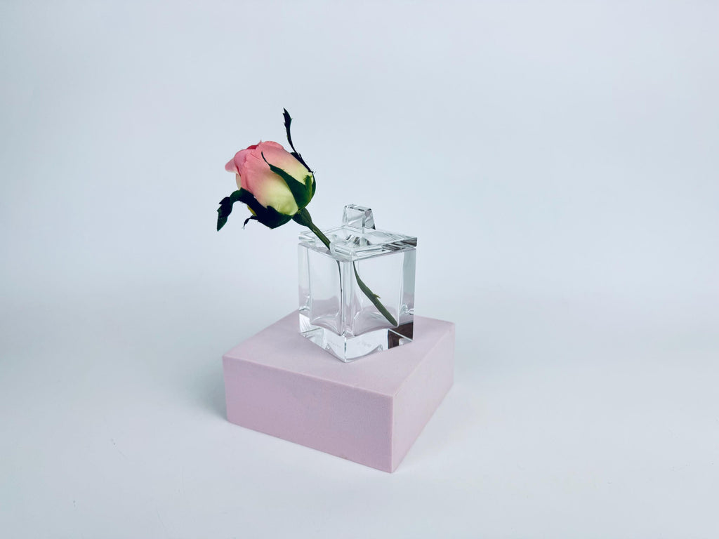 Clear Cartier crystal cube desk box with geometric lid and semicircular pen-rest notch, shown against a red background.