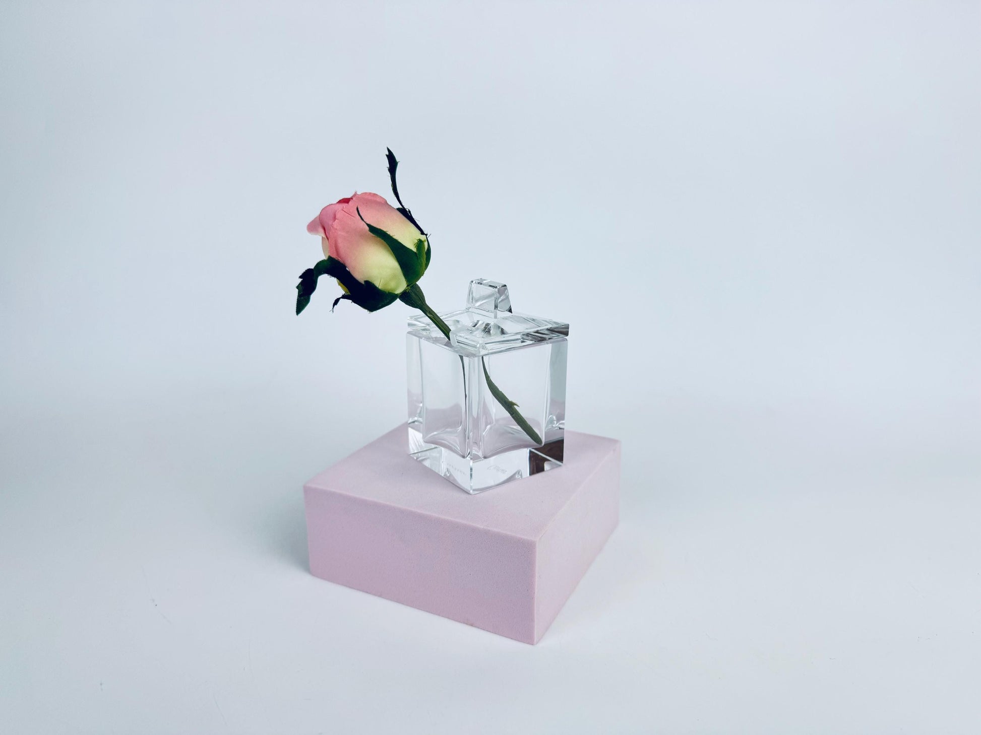 Clear Cartier crystal cube desk box with geometric lid and semicircular pen-rest notch, shown against a red background.