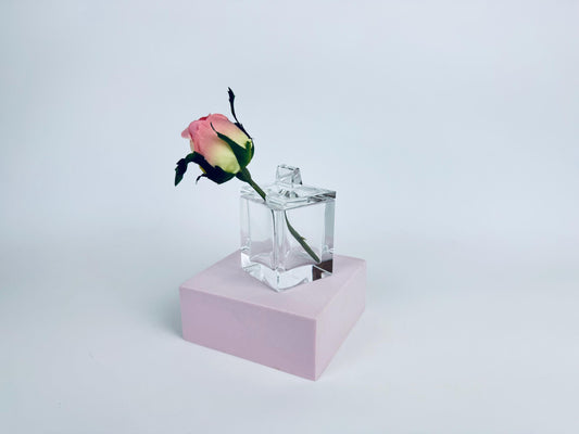 Clear Cartier crystal cube desk box with geometric lid and semicircular pen-rest notch, shown against a red background.