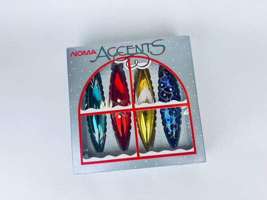 Boxed set of four vintage 1990s NOMA Accents blown glass Christmas ornaments in colourful red, blue, turquoise, and gold with hand-painted detail.